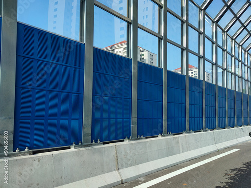 SELANGOR, MALAYSIA - JULY 18, 2020: Noise barriers are installed along the vehicle lane bordering the residence to prevent noise pollution to the surrounding locals. photo