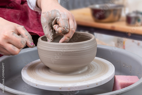 Close up of female potter hands shaping handcraft crockery in studio. photo