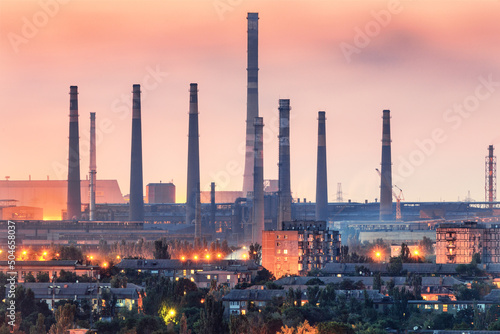 Steel plant at sunset in Mariupol, Ukraine before war. Steel factory with smokestacks. Steel works, iron works. Heavy industry. Industrial landscape with metallurgical combine, smokes, lights photo