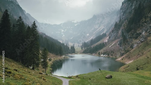 Zoom out Time-Lapse to reveal a majestic Swiss alpine lake panorama with rain