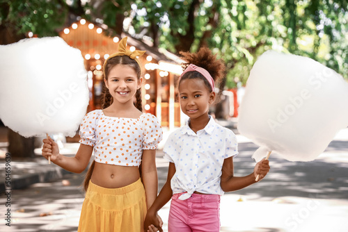 Cute little girls with cotton candy outdoors