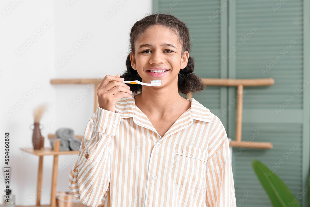 African-American teenage girl brushing teeth in bathroom African-American teenage girl brushing teeth in bathroom
