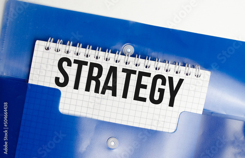 Strategy word on the white background and blue file folder