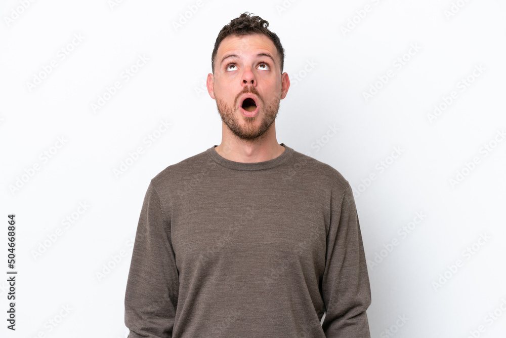 Obraz premium Young Brazilian man isolated on white background looking up and with surprised expression