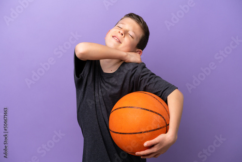 Little boy playing basketball isolated on purple background suffering from pain in shoulder for having made an effort