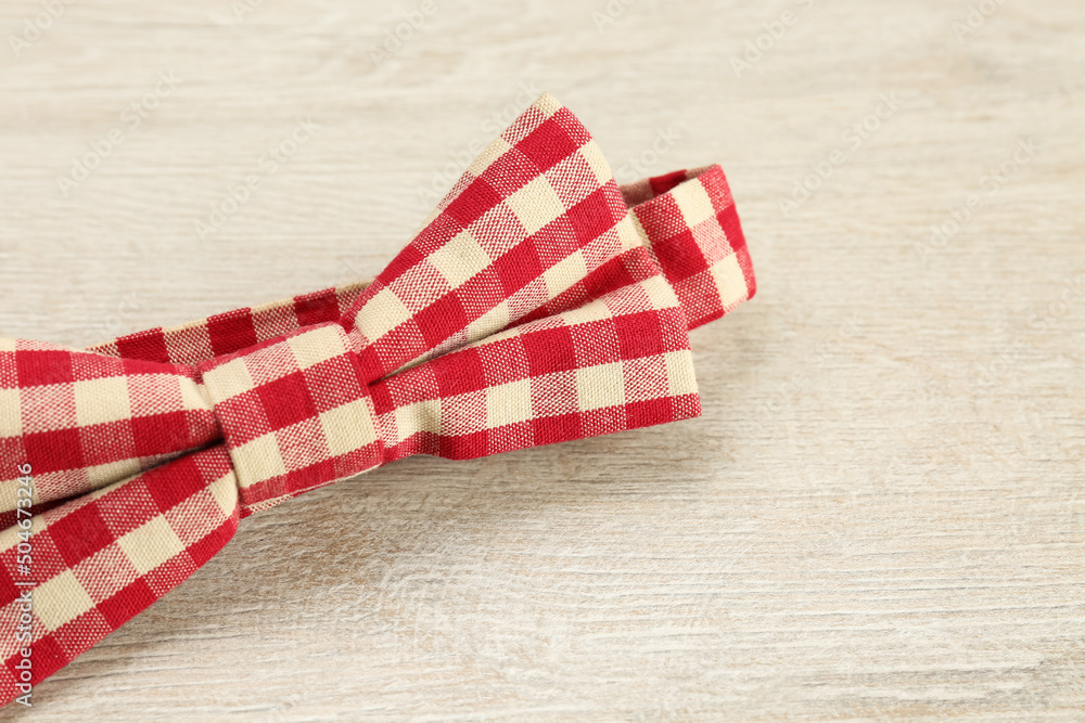 Stylish red and white gingham bow tie on wooden background, closeup Stylish red and white gingham bow tie on wooden background, closeup