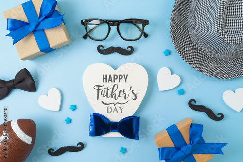 Flat lay composition for Father's day. Heart shape, hat, gift box and decorations on blue background. Top view