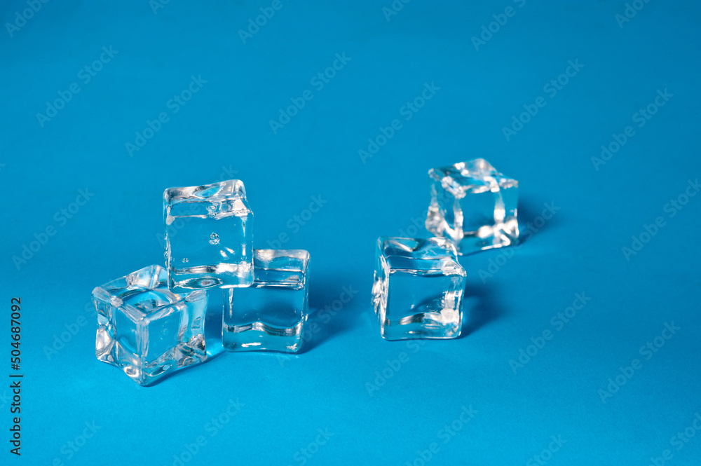 Clear ice cubes for cooling drinks on a blue background. Clear ice cubes for cooling drinks on a blue background.