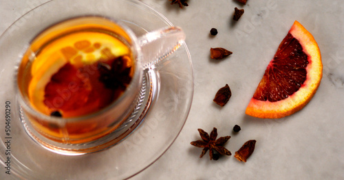 Blurred Mulled Wine in Glass with focused Blood Orange and Star Anise garnish on marble