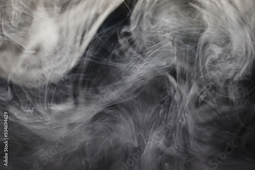 Bizarre swirls of gray smoke creeping in the dark. Clouds of gray smoke.