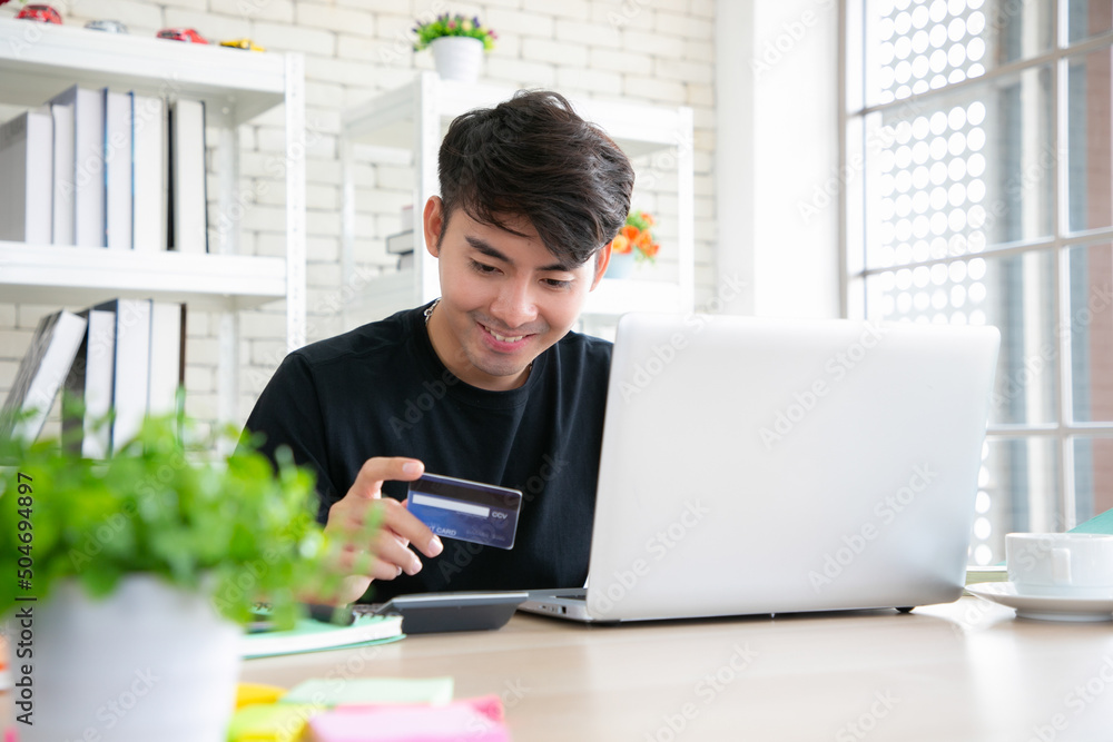 Fototapeta premium Asian man hands holding credit card and using laptop. Online shopping