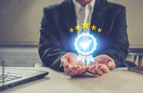 Businessman hand holding icon quality Assurance Service Guarantee Standard .