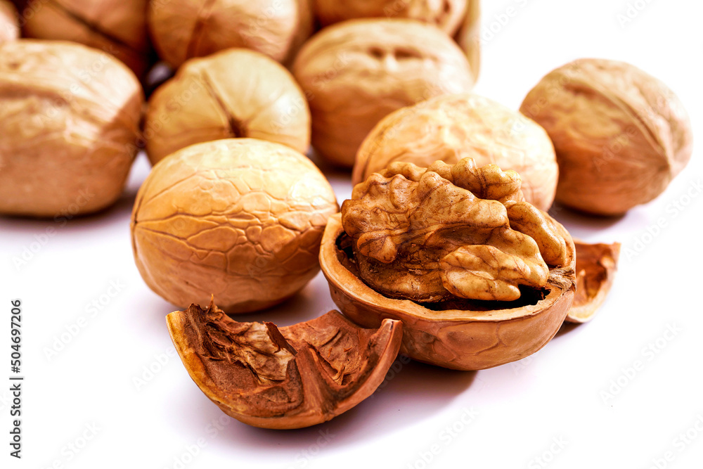 Pile of walnuts and one opened walnut isolated on white background Pile of walnuts and one opened walnut isolated on white background