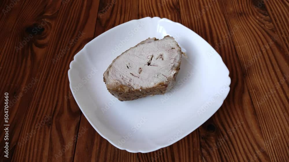 A piece of baked meat on a white plate. Meat with crispy crust and grilled spices in home kitchen. Cooking delicious and fragrant meat. A piece of baked meat on a white plate. Meat with crispy crust and grilled spices in home kitchen. Cooking delicious and fragrant meat.