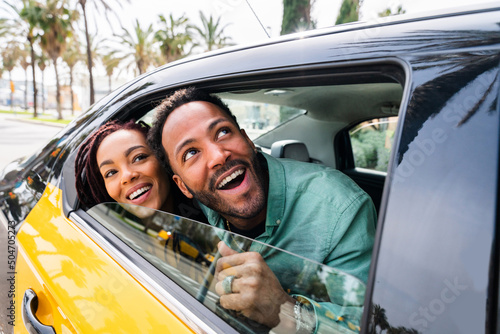 Happy hispanic latino couple taking a taxi