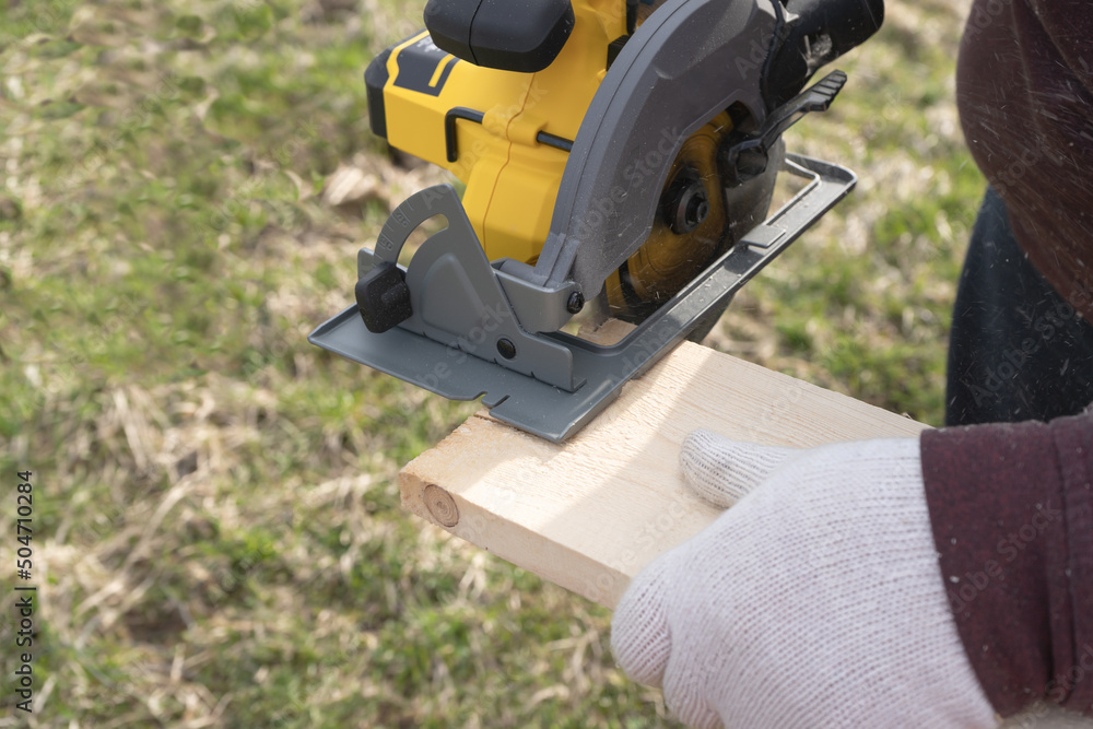 Man sawing board with a circular saw Man sawing board with a circular saw