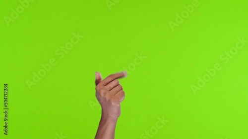 Woman hand calls to come up and lures with fingers makes enticing gestures beckon to himself demonstrates invitation to visit or for conversation located on green studio background