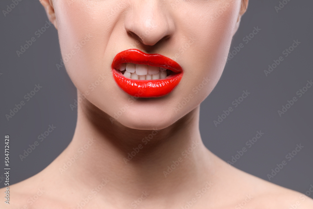 Obraz premium Young woman with beautiful red lips on grey background, closeup