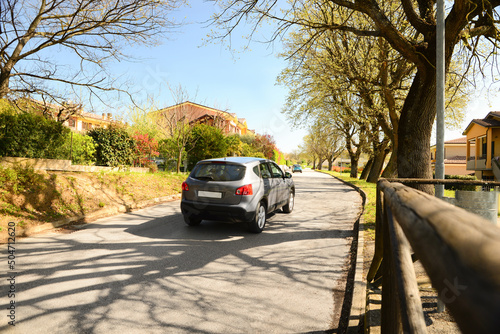 Picturesque view of beautiful suburban street with cars on sunny spring day photo