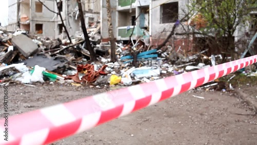 Enclosing red-white signal tape area near a destroyed residential building after the bombing of the Ukrainian city by Russian aircraft. Ruins of city Chernihiv of terrorist attacks, bomb shelling. photo