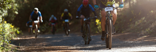 Group of athletes mountain biking on forest trail, front view. Mountain bike race photo