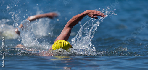 Obraz na płótnie Triathlon swimmers churning up the water two swimmers in races in triathlon