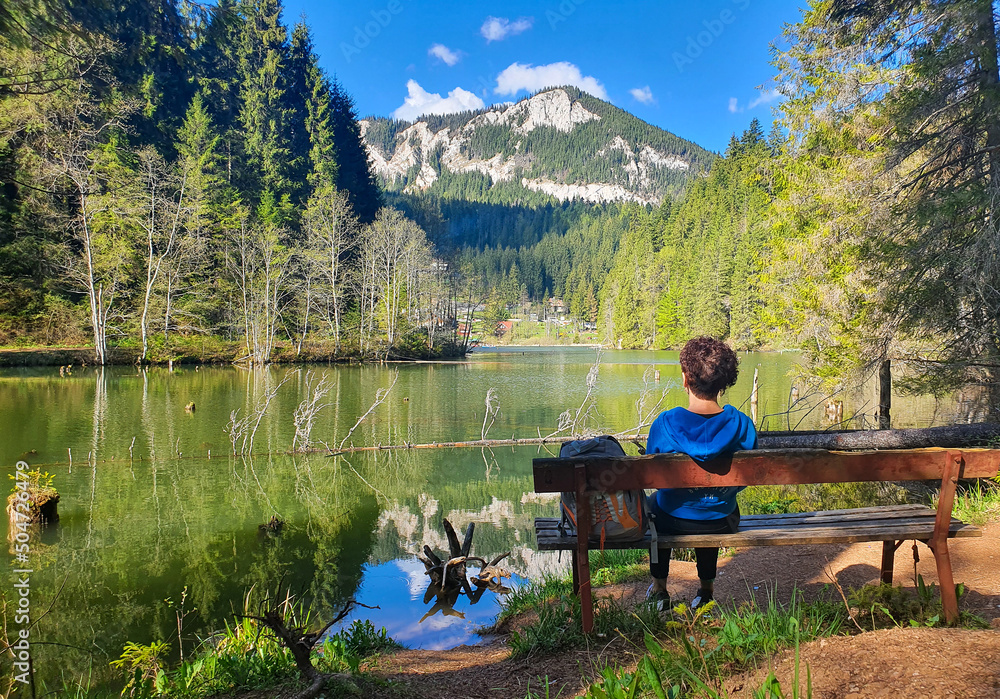 a beautiful landscape with a woman sitting on the bench and looking at a mountainous landscape a beautiful landscape with a woman sitting on the bench and looking at a mountainous landscape