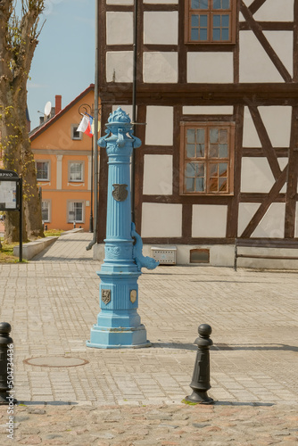 Old traditional blue water pump with gryphon head and crest from Stettin city emblem. old water pump