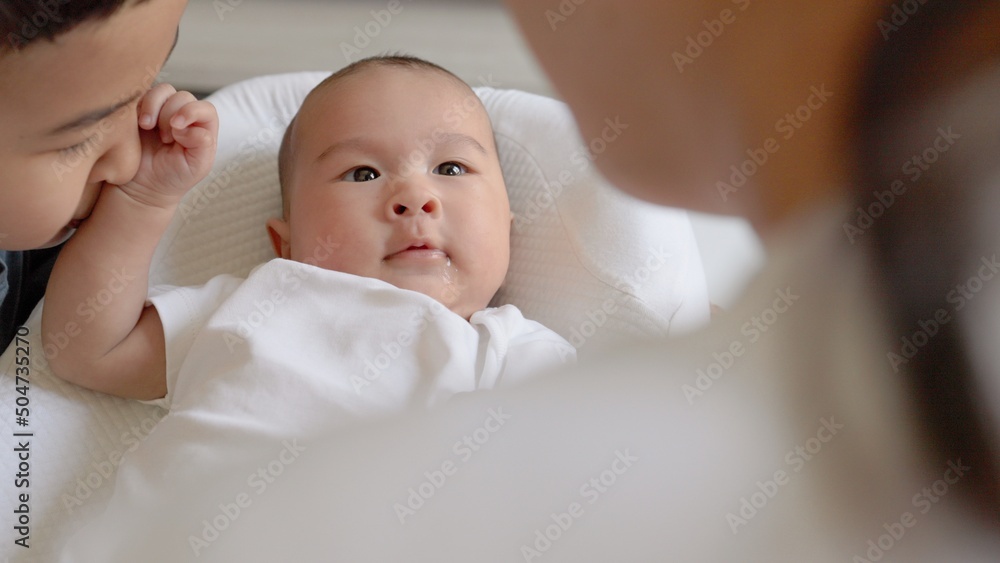 Baby pushes older brother away while mother holding his hand. Happy motherhood, parenthood Baby pushes older brother away while mother holding his hand. Happy motherhood, parenthood