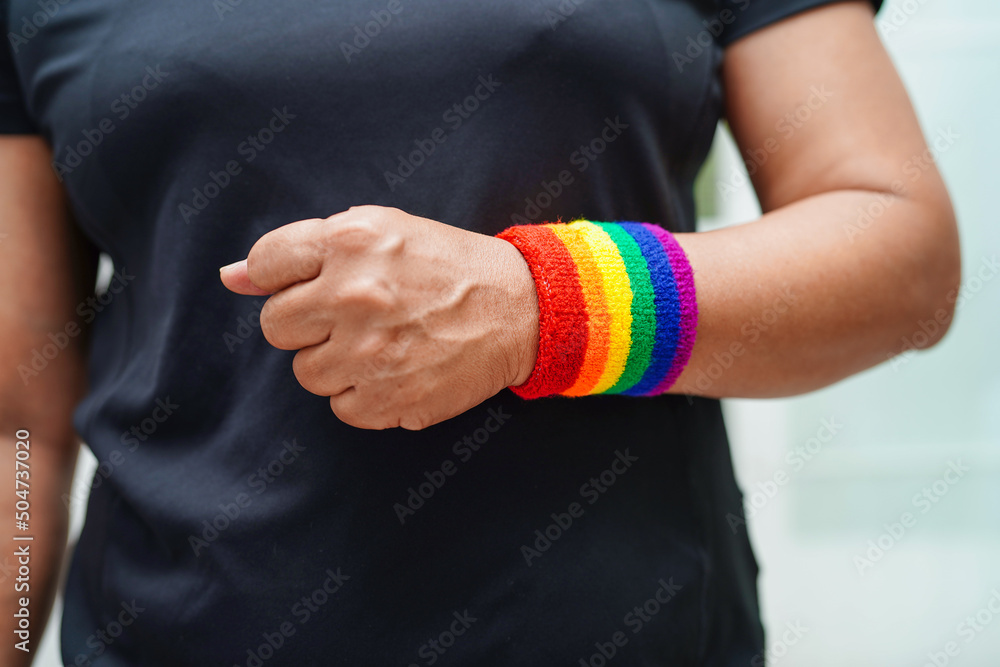 Fototapeta premium Asian woman with rainbow flag, LGBT symbol rights and gender equality, LGBT Pride Month in June, LGBTQ, LGBTI, LGBTQA, LGBTQIA