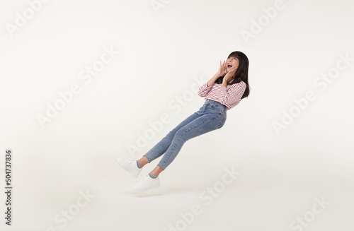 Photography Young beautiful smiling asian girl floating in mid-air shout story and announcement something isolated on white background