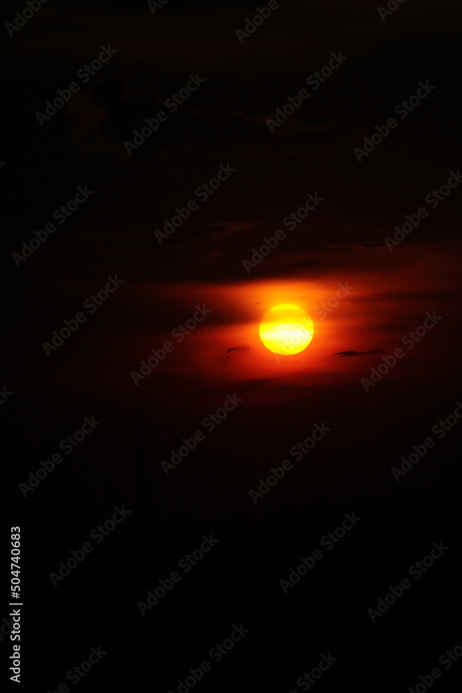 Red sunset with yellow sun against dark sky