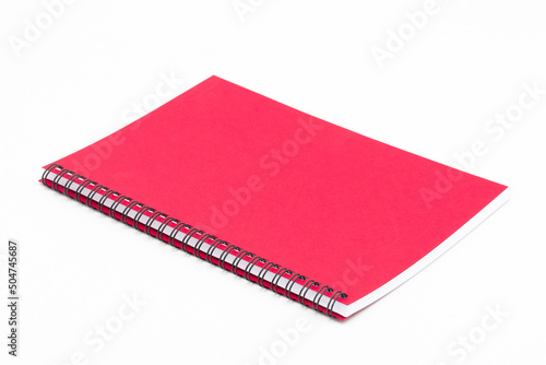 Spiral notebook with red cover on white background
