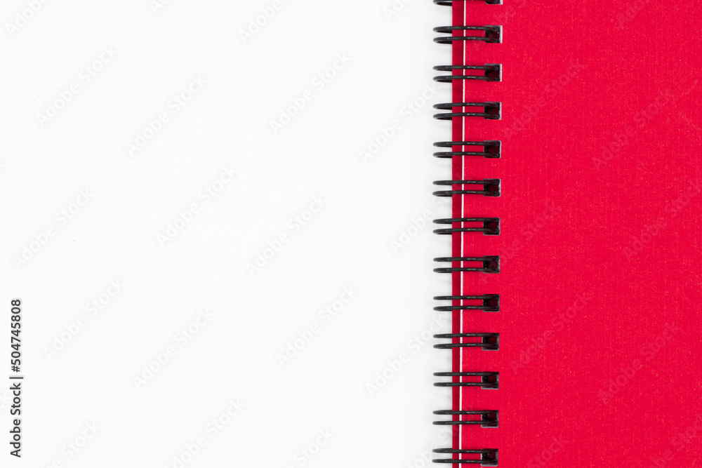 Close up of spirall notebook with red cover on white background Close up of spirall notebook with red cover on white background