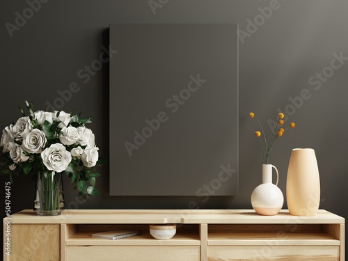 Fototapeta Naklejka Na Ścianę i Meble -  Black poster frame on cabinet in living room interior on empty dark wall.
