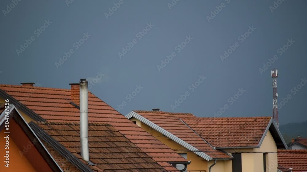 House heating in suburbs, smoke coming out of chimney in wind, gloomy sky House heating in suburbs, smoke coming out of chimney in wind, gloomy sky