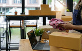Close up young businessman owner packing clothes to cardboard box, Young Owner Woman Start up for Business Online. People with online shopping SME entrepreneur or freelance working concept.