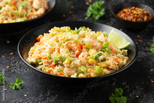 Fotografia Prawn fried rice with eggs and vegetables in black bowl