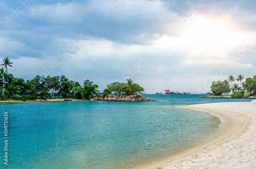 Fototapeta Naklejka Na Ścianę i Meble -  Tropical beach with sand, summer holiday background. Palms and tropical beach with white sand. Sentosa Island, Singapore.