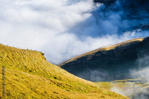 Mountains and clouds in the valley. Natural landscape. Mountain range through...
