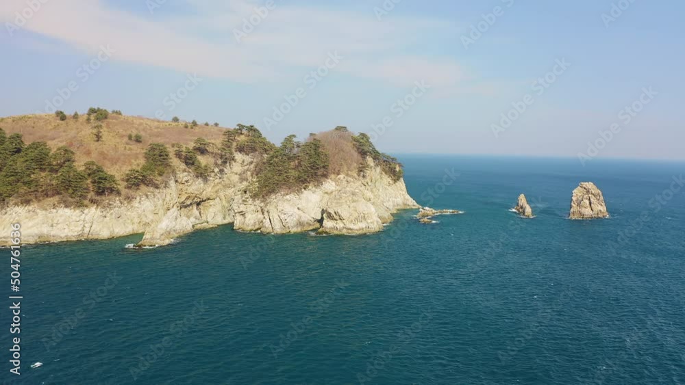 Kekura and rocky Cape Telyakovsky washed by the Sea of Japan on a sunny day. Far Eastern Marine Reserve. National park. Drone view. The concept of protecting protected areas Kekura and rocky Cape Telyakovsky washed by the Sea of Japan on a sunny day. Far Eastern Marine Reserve. National park. Drone view. The concept of protecting protected areas