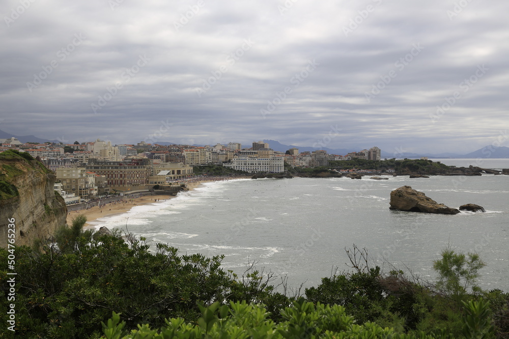 Beach landscape France: View to the beach Grand Plage of Biarritz with its ancient seaside resort architecture at stormy weather with breakers at the rocky bay of Biscay in the Atlantic Ocean