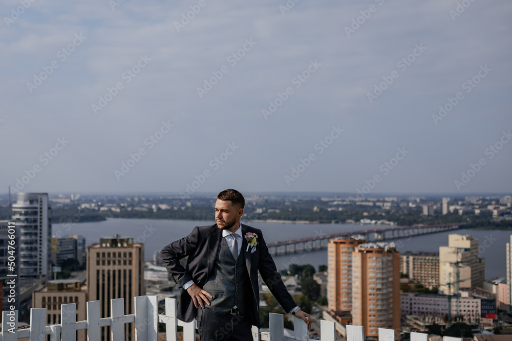 City view. High skyscrapers and a bridge across the river. Business center. Stylish and the adorable groom on the roof of the house. Beautiful view City view. High skyscrapers and a bridge across the river. Business center. Stylish and the adorable groom on the roof of the house. Beautiful view
