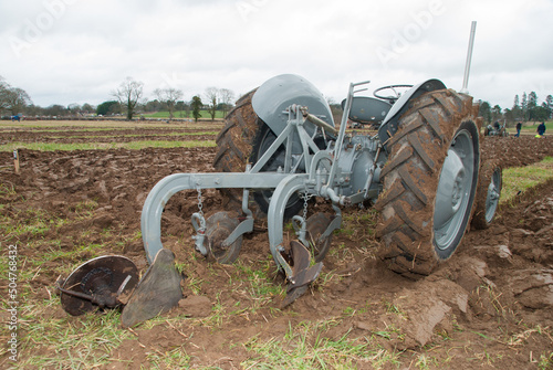 Grey vintage Massey Ferguson tractor in a ploughed field. photo