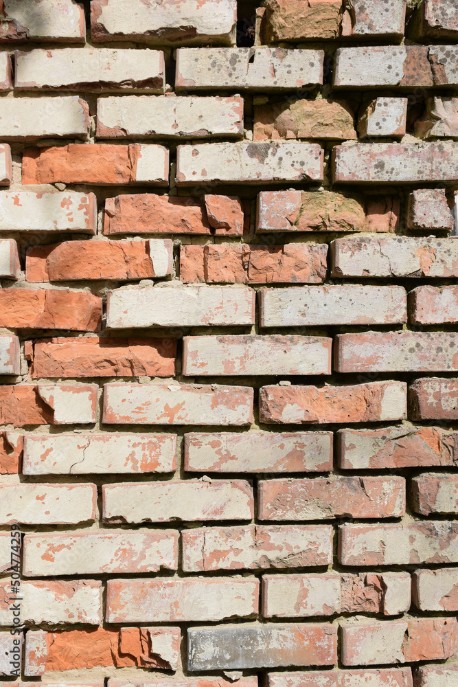 Obraz premium Old brick cracked wall with deep gaps between the blocks