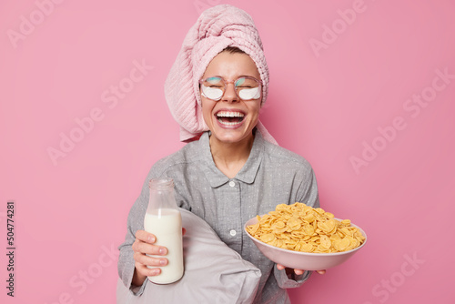 Φωτογραφία Positive young female model going to eat delcious healthy breakfast holds bowl o