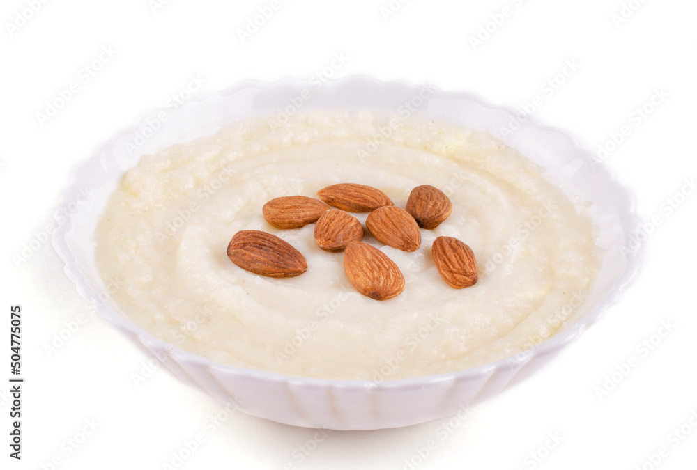 Semolina porridge with whole almonds in a beautiful bowl (plate) on a white isolated background. Space for text. Semolina porridge with whole almonds in a beautiful bowl (plate) on a white isolated background. Space for text.