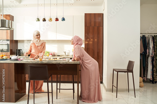 Muslim women spending leisure time together in kitchen