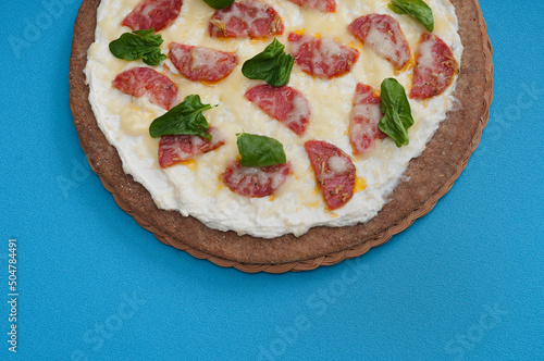 Pizza dietary with salami and cheese on a blue background.