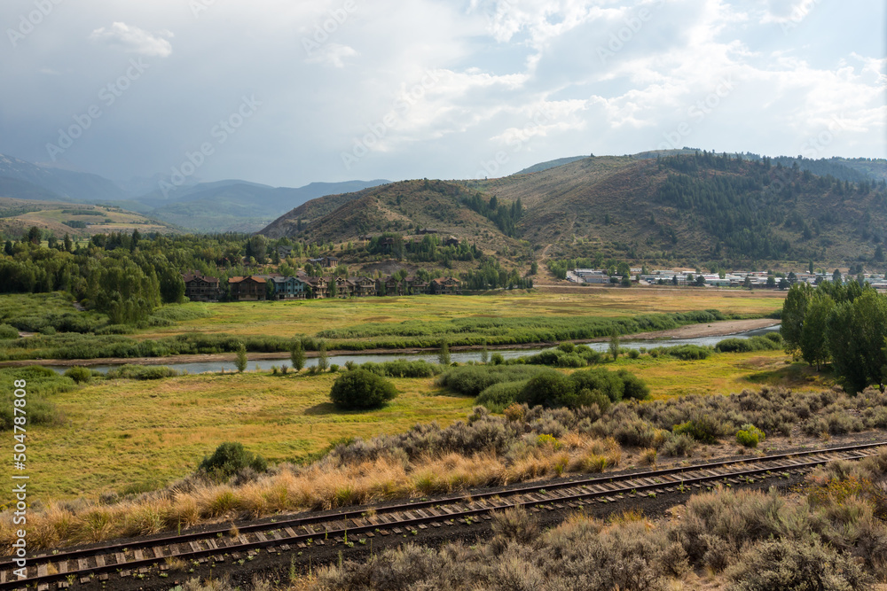 Beautiful Colorado landscape with river and mountains and railroad tracks in the foreground